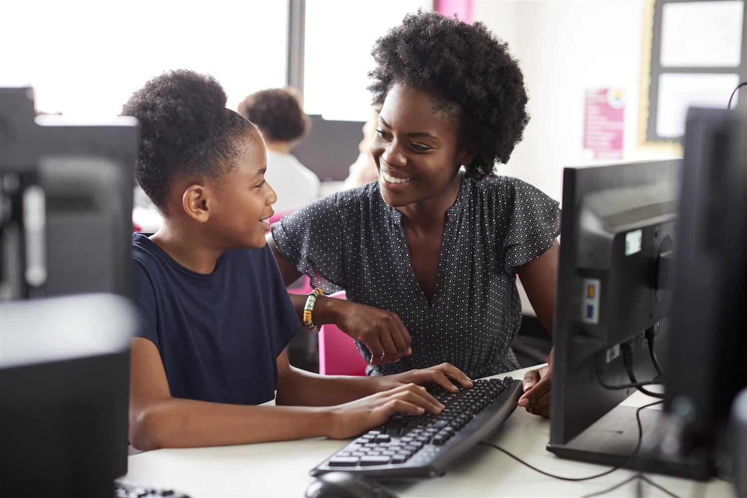 Student and teacher at a computer. Student and teacher at a computer.