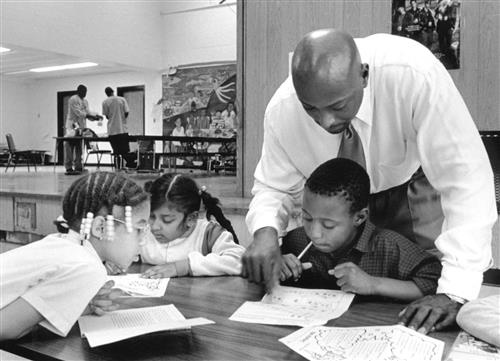 A young Earl Martin Phalen tutoring three students A young Earl Martin Phalen tutoring three students